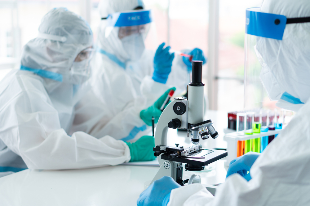 Doctors examine blood samples for diseases, using proper PAPR outfits to keep themselves safe and make sure samples are not contaminated. 