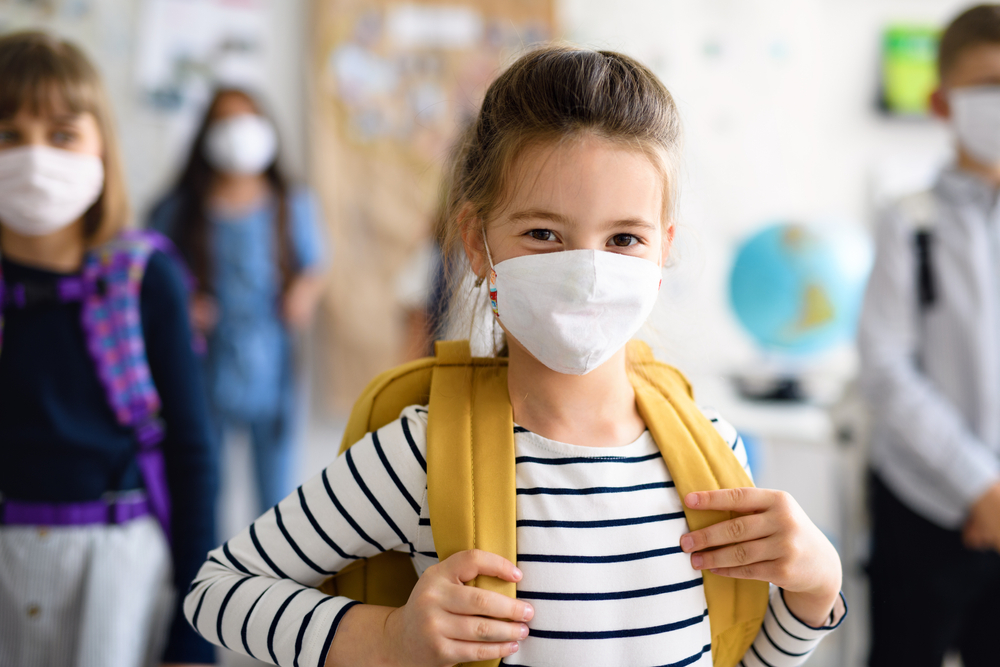 Child at school wearing an n95 mask. Proper mask policies are one of several ways schools can prevent the spread of COVID-19.